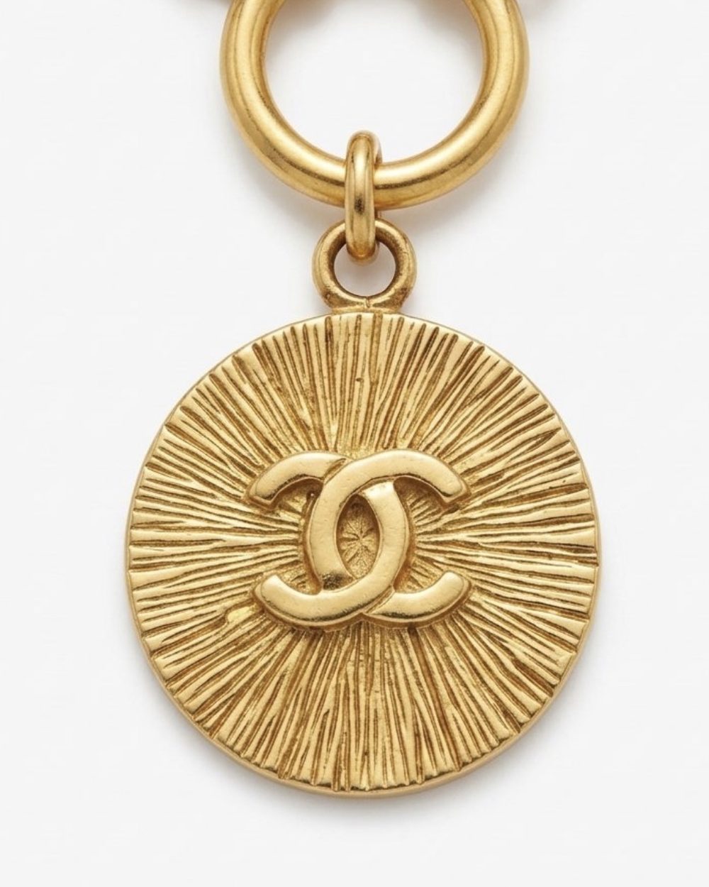 Sunburst on cord, charm close-up — Maison Dorée vintage charm necklace
