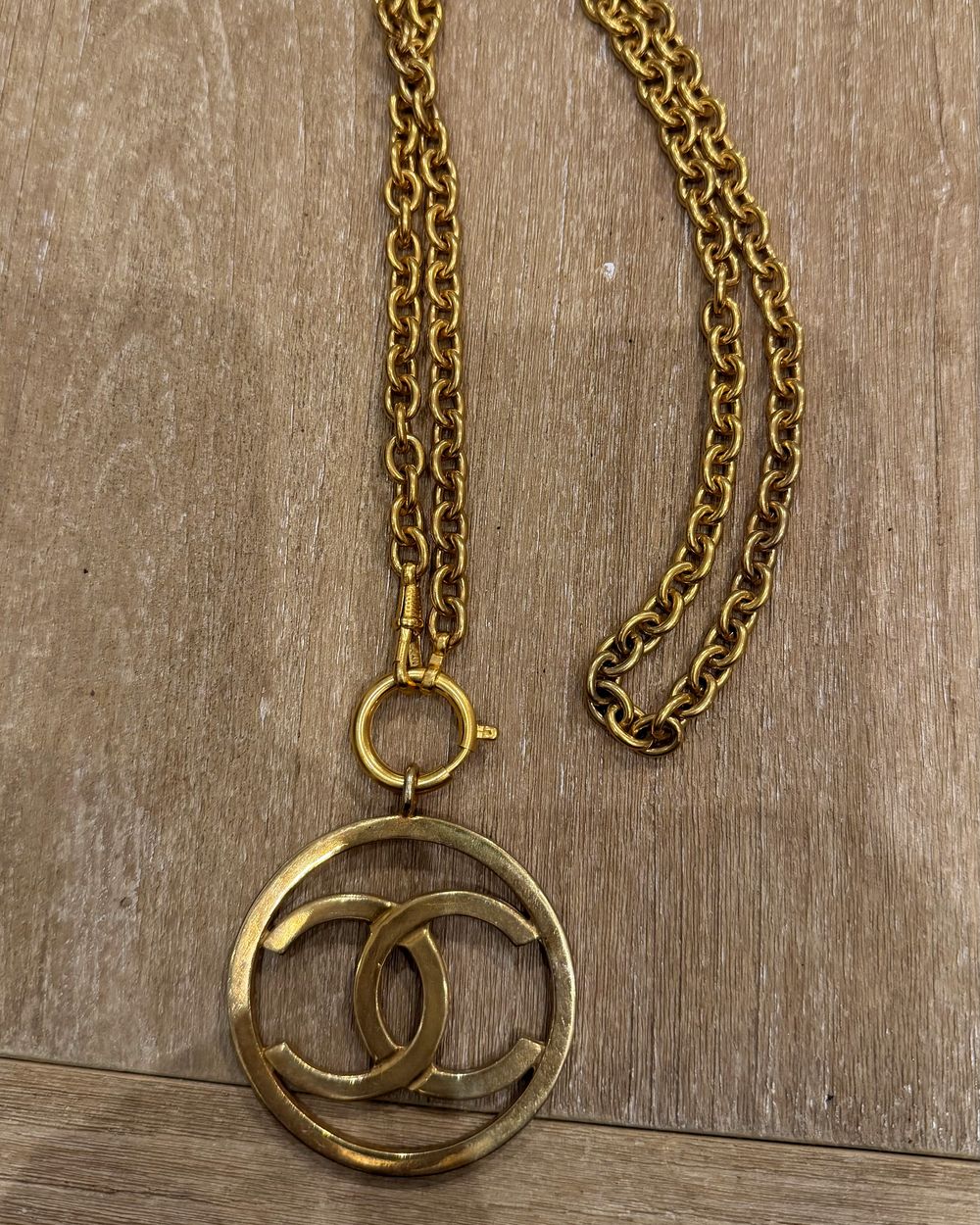 Open Circle on chain, flat lay on oak — Maison Dorée vintage charm necklace