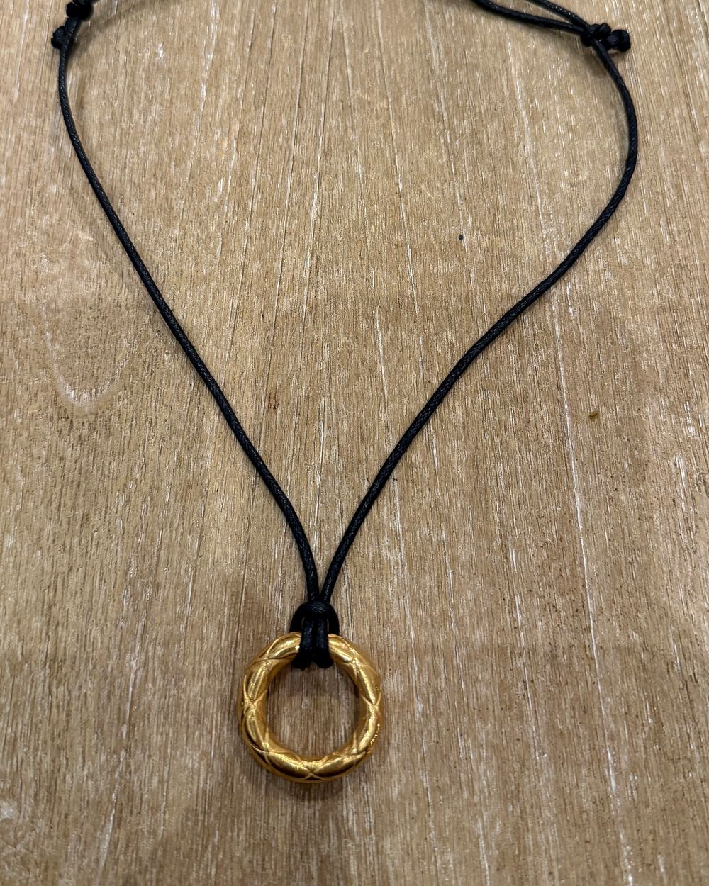 Quilted Ring on cord, flat lay on oak — Maison Dorée vintage charm necklace