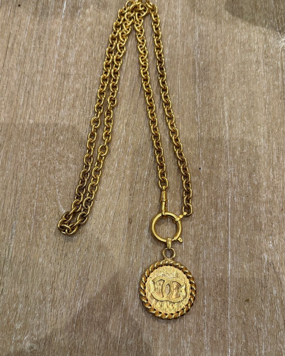 Rope Medallion on chain, flat lay on oak — Maison Dorée vintage charm necklace